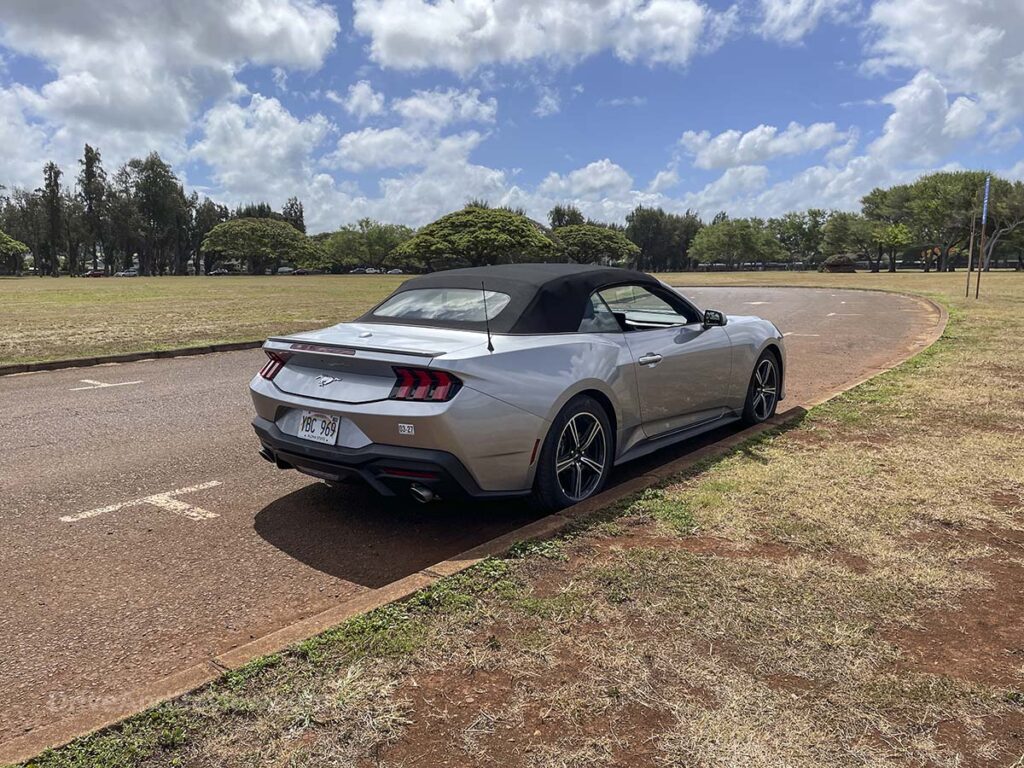 2025 Ford Mustang convertible parked on the side of the road with the top up