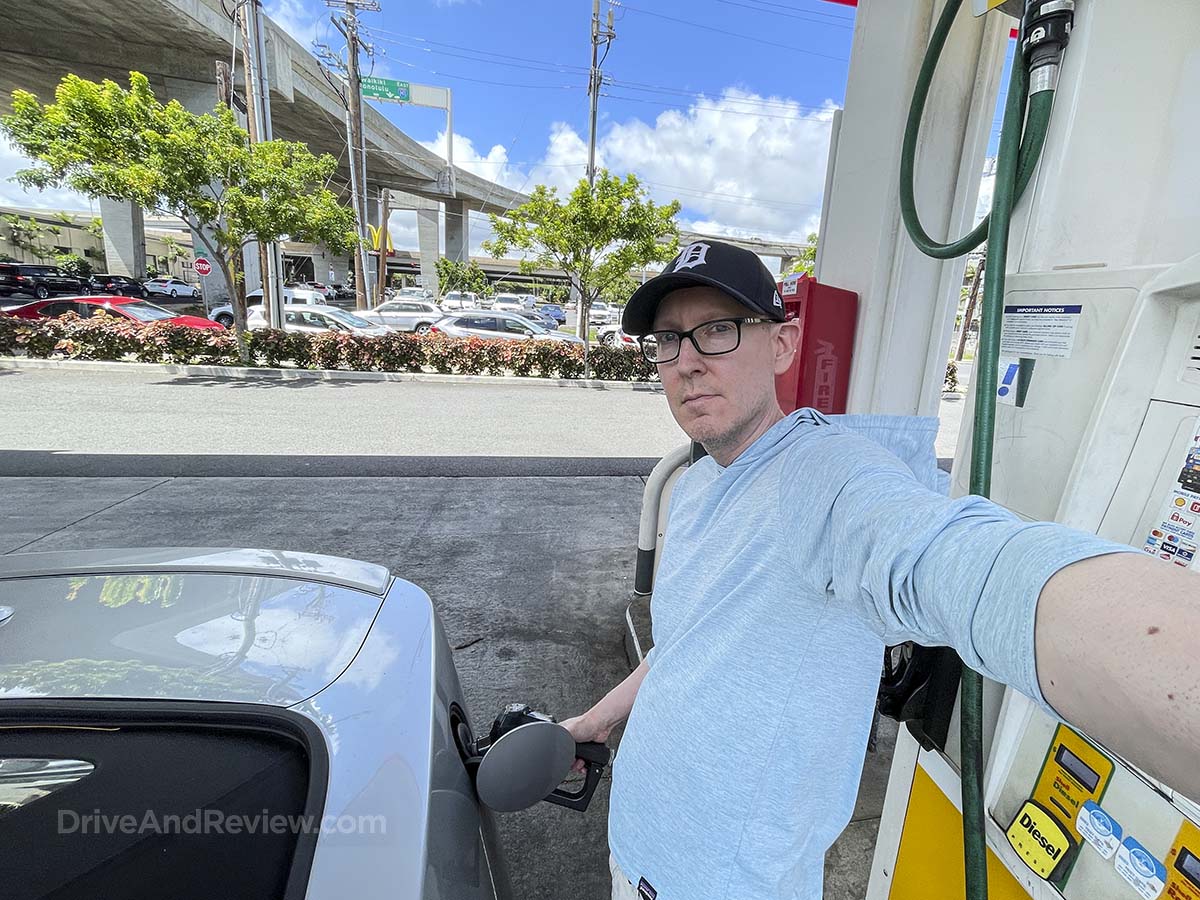 Scott filling up his 2025 Ford Mustang convertible rental car at the gas station