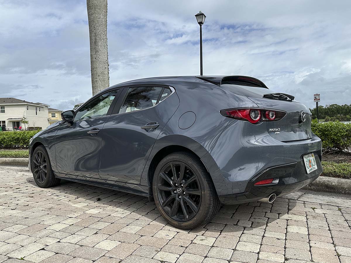 Gray 2026 Mazda 3 with black wheels low rear 3/4 view