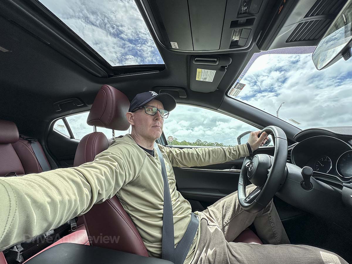 Scott Leazenby driving a 2026 Mazda 3 with a red interior