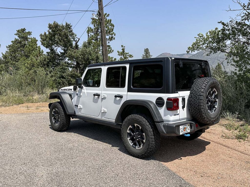 White 2025 Jeep Wrangler Rubicon 4XE rear three-quarter view in the Colorado mountains