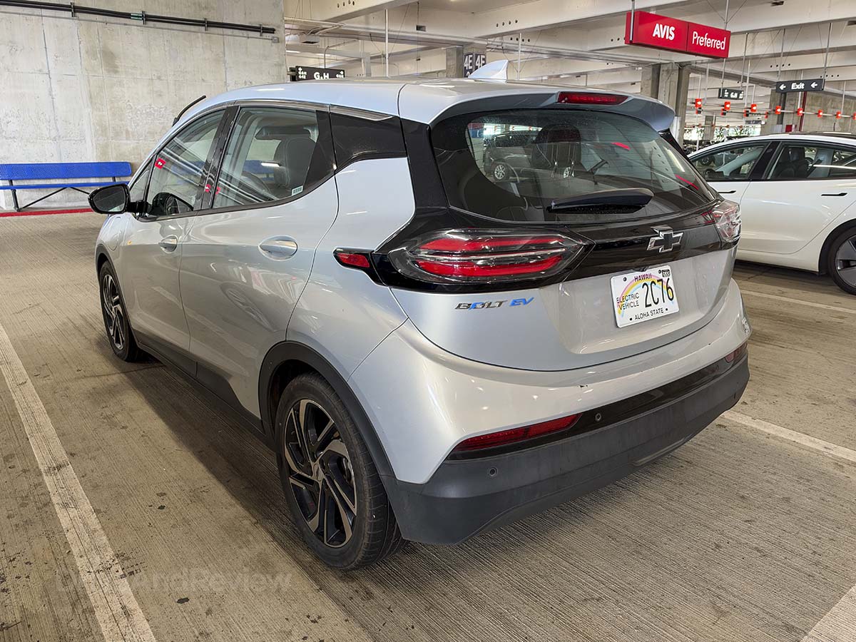 Silver 2024 Chevrolet Bolt rear 3/4 view parked at the Avis rental car parking garage Honolulu airport