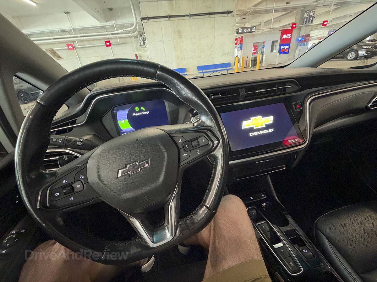 Sitting behind the wheel of a 2024 Chevrolet Bolt with a black interior