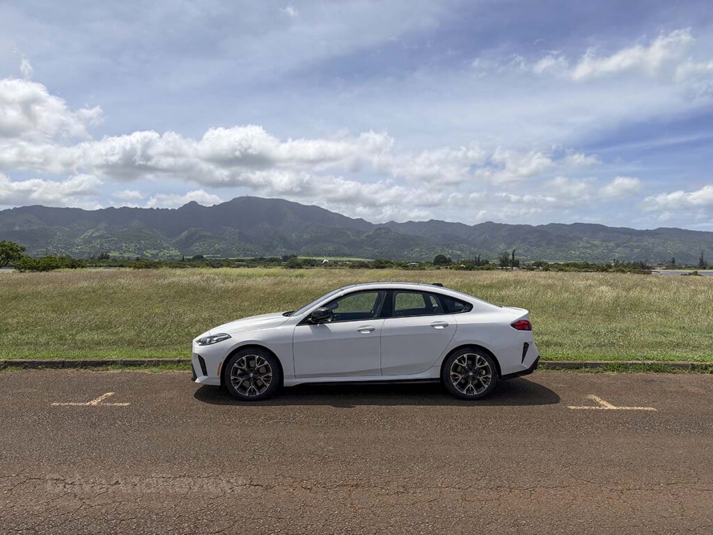 White 2026 BMW 228 xDrive parked in front of the mountains in Haleiwa Hawaii